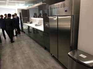 People gathered in suits talking in a modern office kitchen